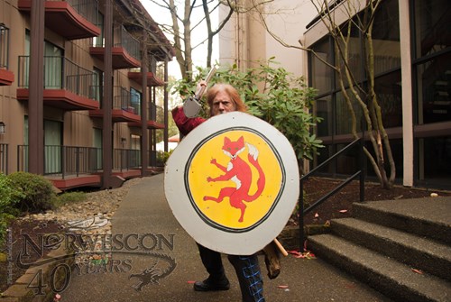 Visitor posing with sword and shield